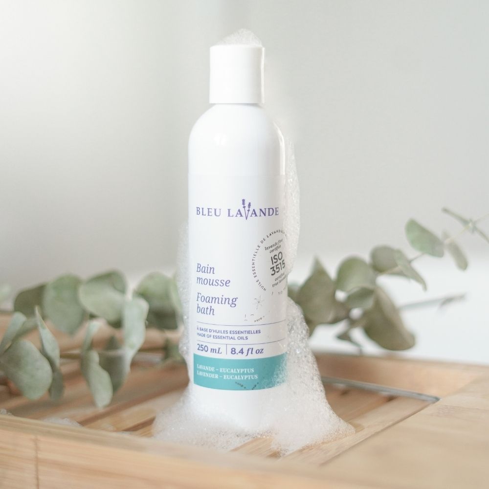 Bain mousse lavande-eucalyptus sur un pont de bain en bois avec des branches d'eucalyptus