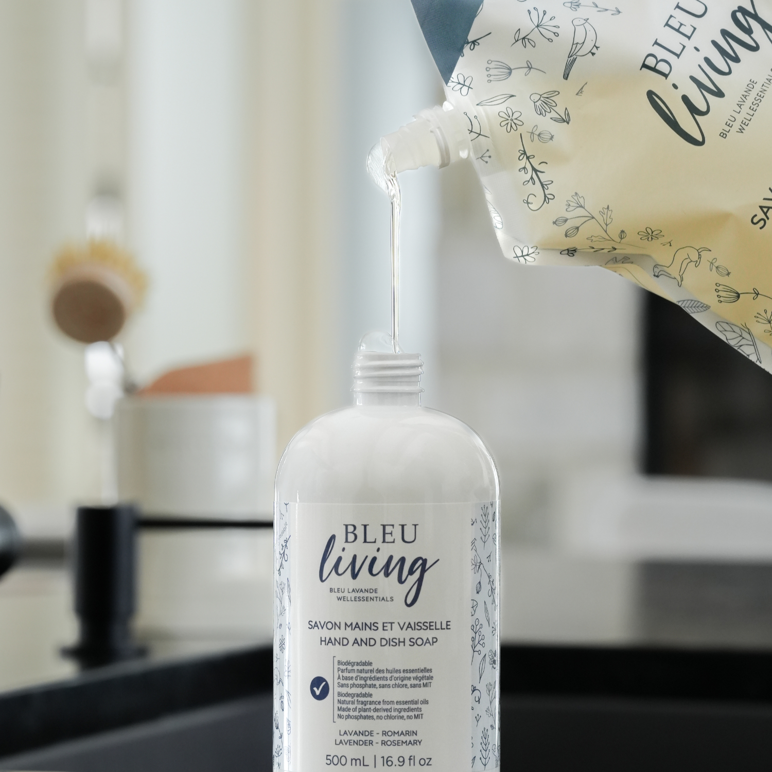 Savon pour les mains et la vaisselle lavande et romarin 1L en train d'être versé dans le 500 ml